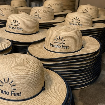 Custom sun hats in bulk stacked for an event